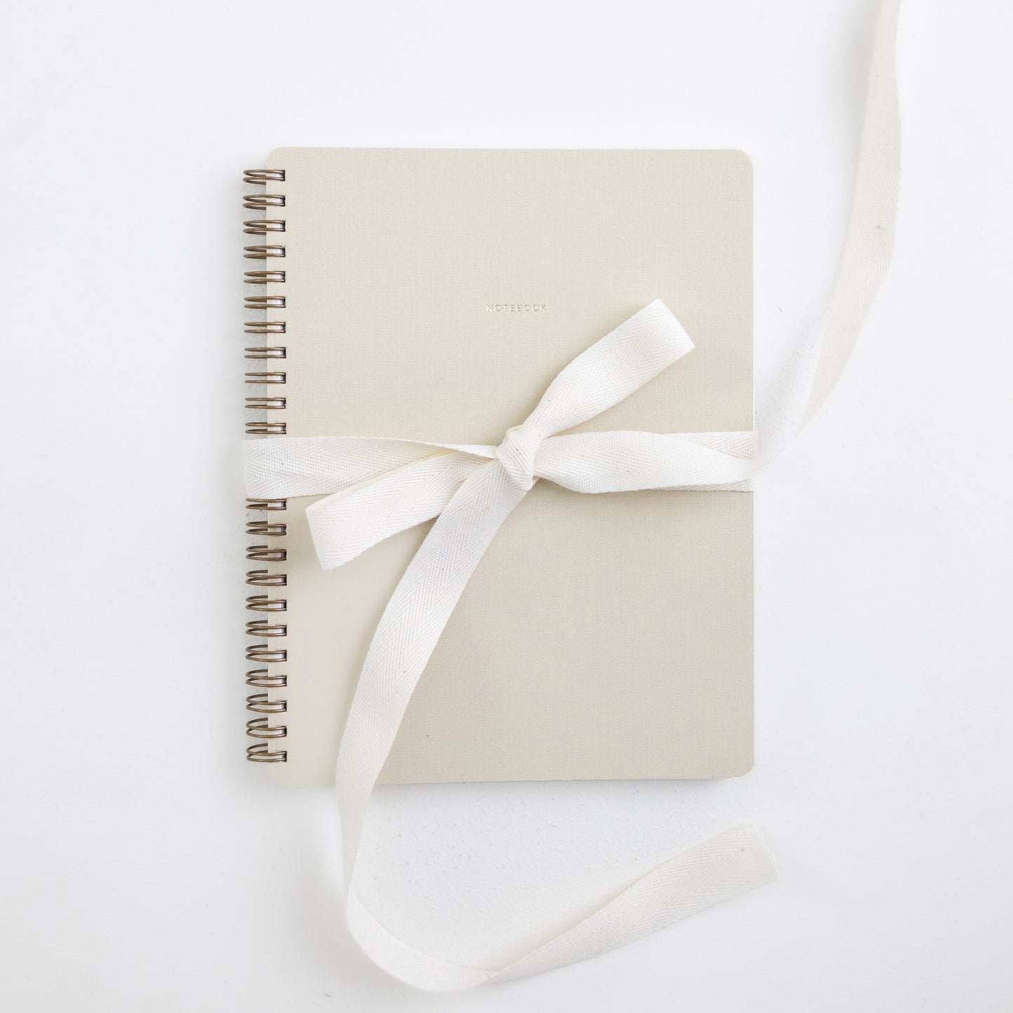 Notebook Aime cor Marfim com capa em tecido de algodão e laço decorativo.